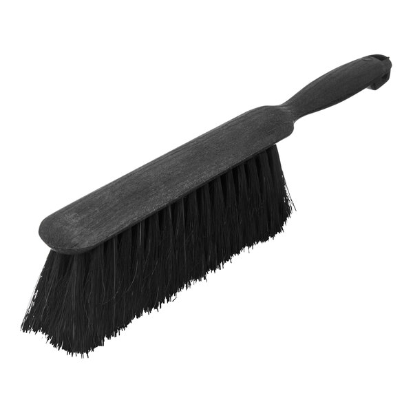 A close-up of a black Carlisle counter brush with a handle.