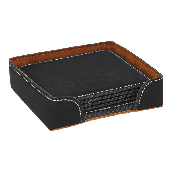 A black square leatherette coaster with white stitching on a table.