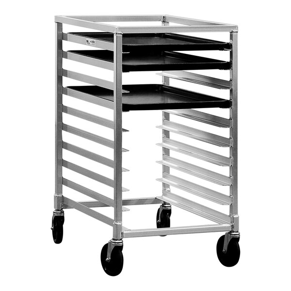 A New Age metal sheet pan rack with black trays on wheels.