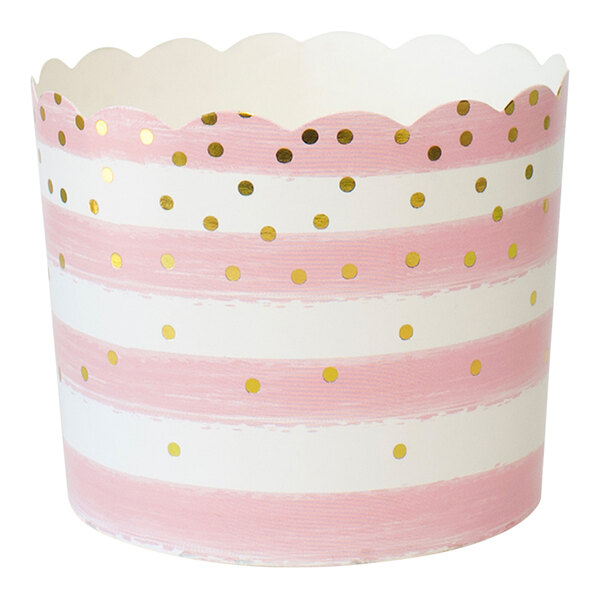 A close-up of a pink and white striped baking cup with gold dots.