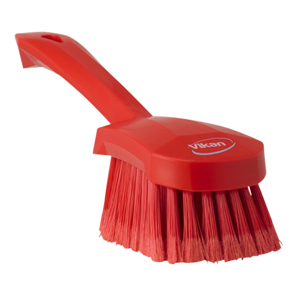 A Vikan red washing brush with a short handle.
