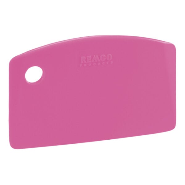 A pink plastic Remco mini bench scraper with a white circle on it.