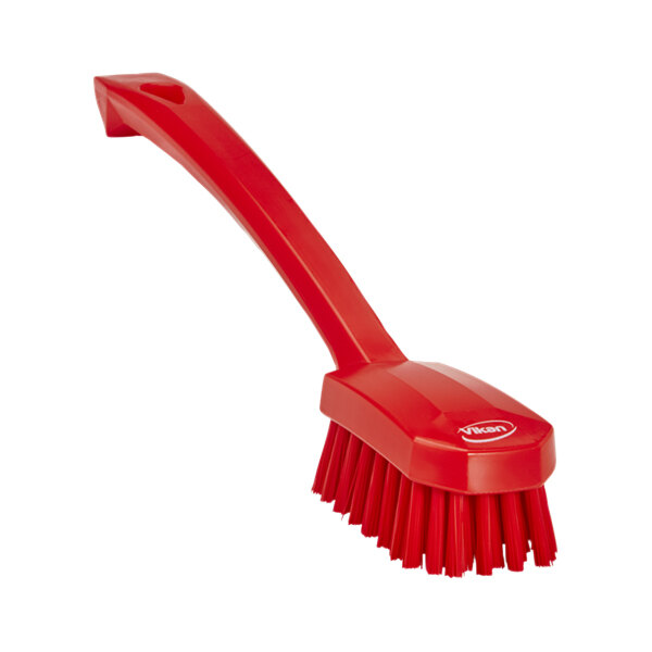 A close-up of a Vikan red utility brush with a handle.