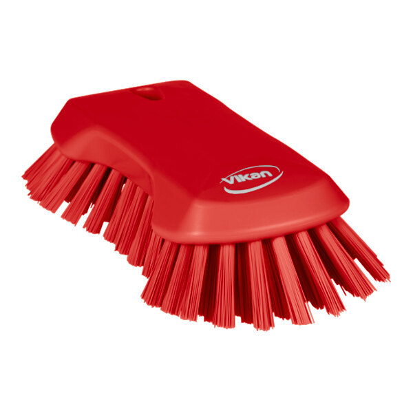 A red Vikan scrub brush with angled extra stiff bristles.