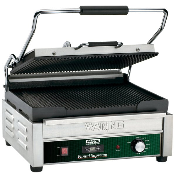 A Waring Panini Supremo grill with a black and green cover and a black handle.