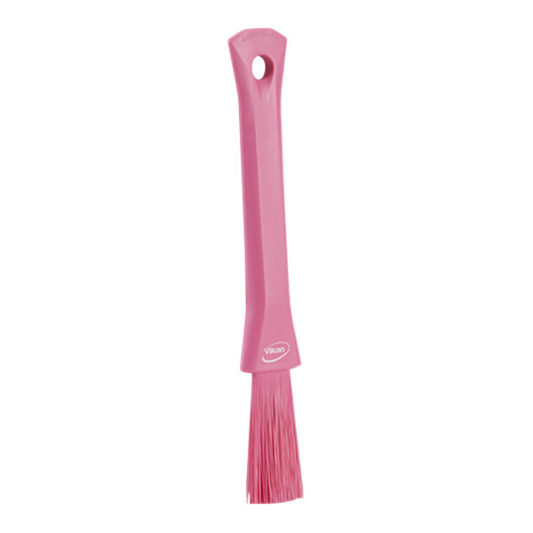 A pink rectangular Vikan detail brush with a hole in the handle.