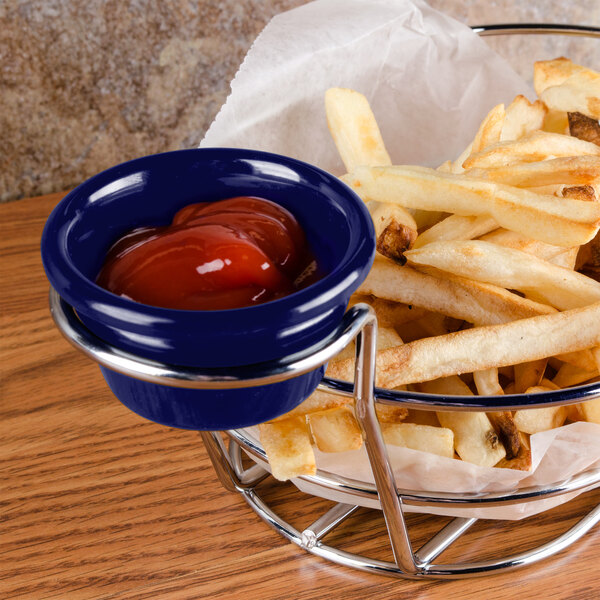 A bowl of french fries with ketchup served in a navy blue smooth melamine ramekin.
