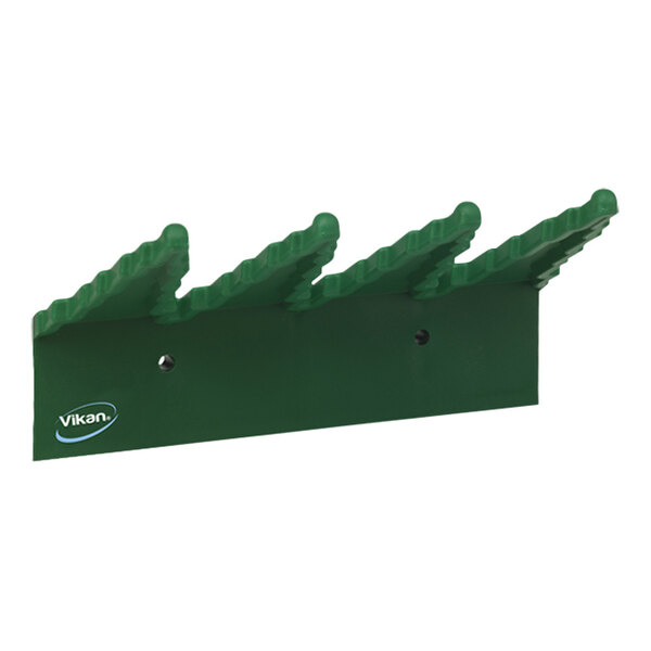 A green plastic Vikan wall bracket with spikes.