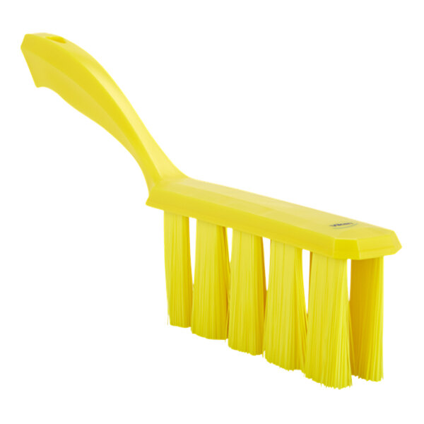 A yellow bench brush with medium bristles and a yellow plastic handle.