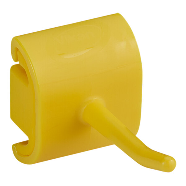 A yellow plastic Vikan wall bracket with a hook.