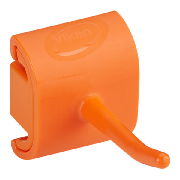 An orange plastic wall bracket with a hook.