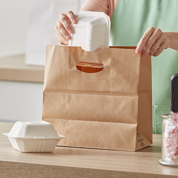 A woman using a Duro Kraft paper bag with die cut handles to put a white styrofoam container in.