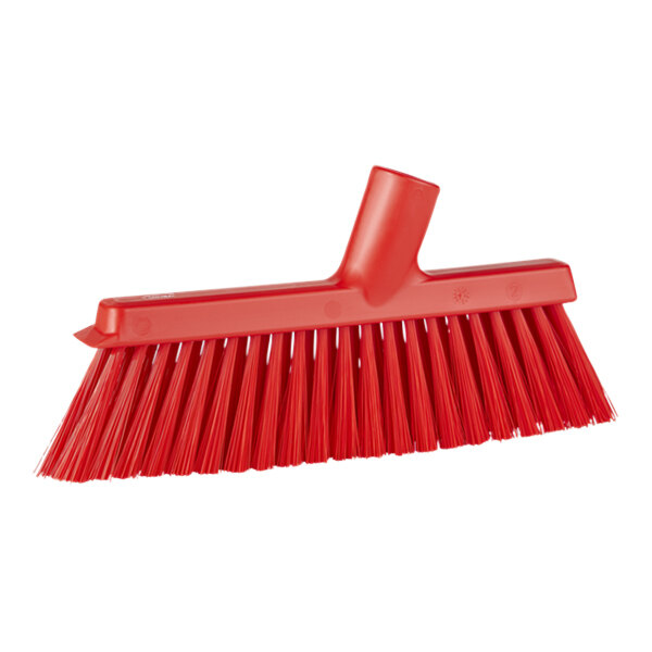 A red broom head with long, angled bristles.