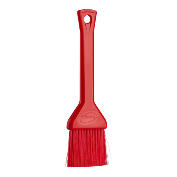 A red Vikan pastry brush with a plastic handle.