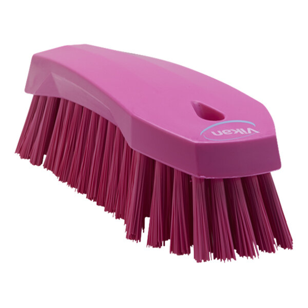 A pink Vikan scrub brush with a handle and stiff bristles.