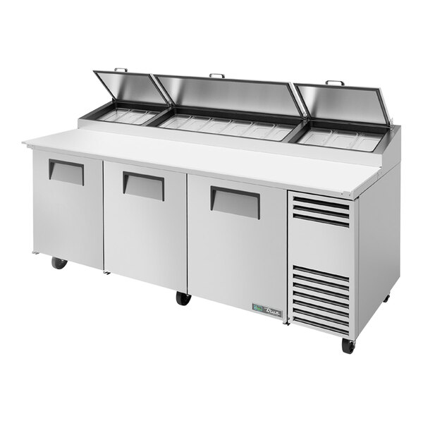 A True refrigerated pizza prep table with three doors.