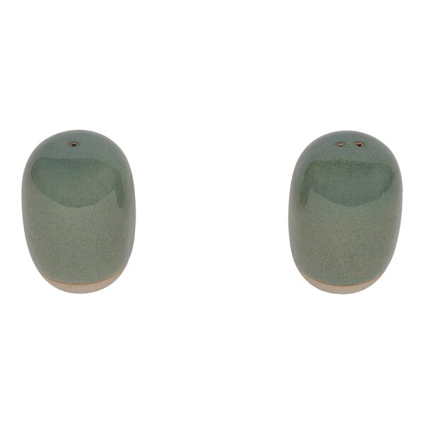 Two green ceramic Front of the House salt and pepper shakers on a table.