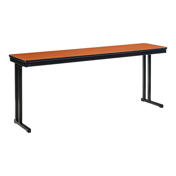 A long wooden National Public Seating folding table with black cantilever legs and a wild cherry top.