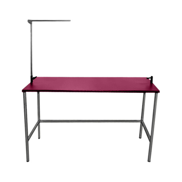 A pink stainless steel Groomer's Best grooming table with metal legs.