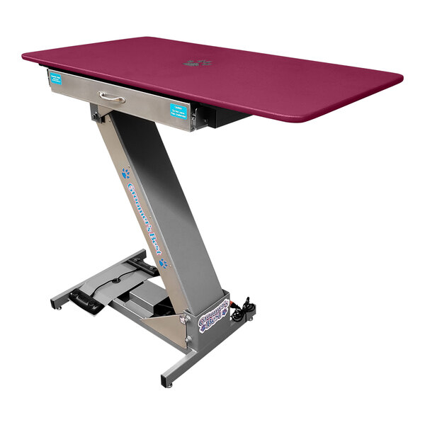 A rectangular pink Groomer's Best grooming table with a silver base.
