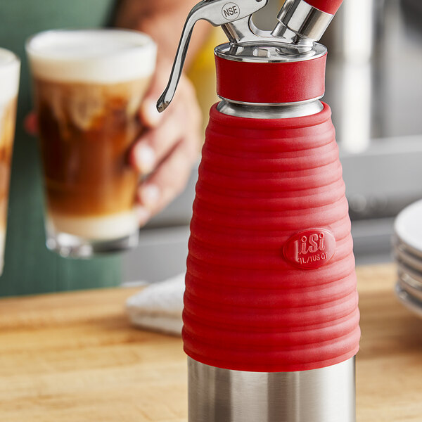 A red and silver iSi heat protection sleeve on a cream whipper.