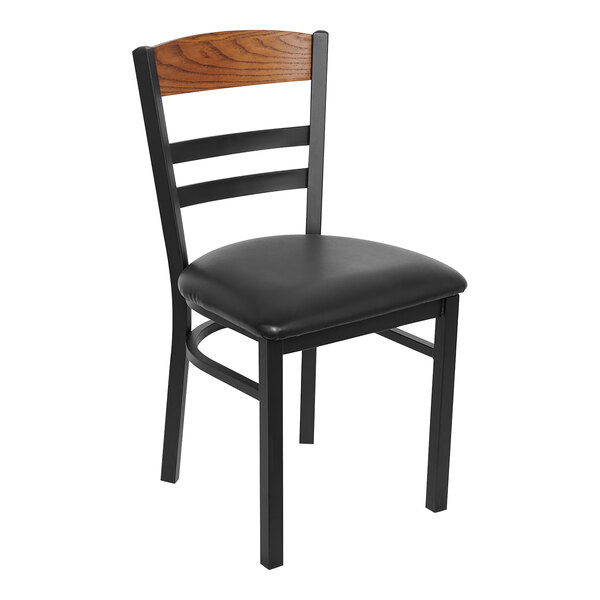 A BFM Seating black steel side chair with a black vinyl seat and wood back.