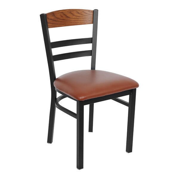 A BFM Seating Barrick Sand Black Steel Side Chair with Autumn Ash Wood Back Panel and Light Brown Vinyl Seat.