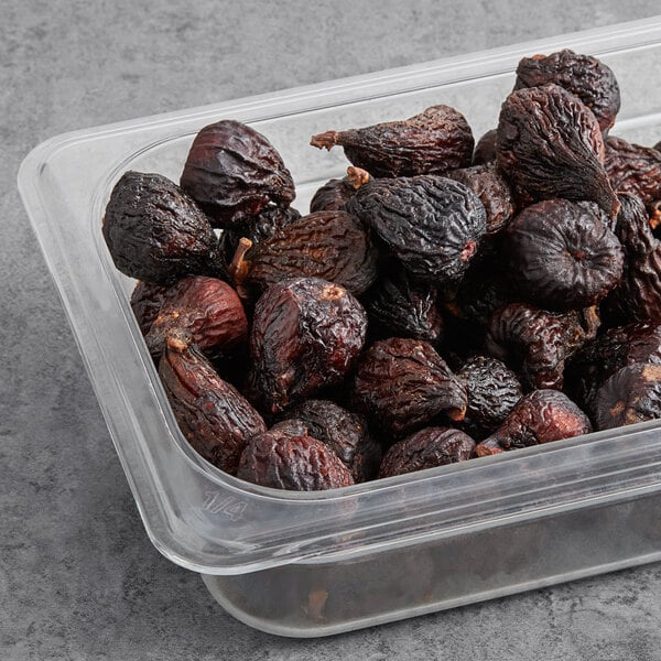 A plastic container with round brown Dried Black Mission Figs.