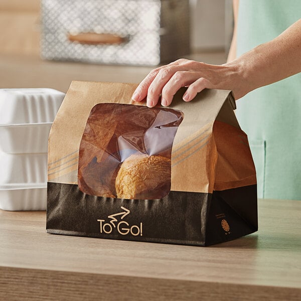 A person holding a Bagcraft EcoCraft vented rotisserie chicken bag with to go seal.