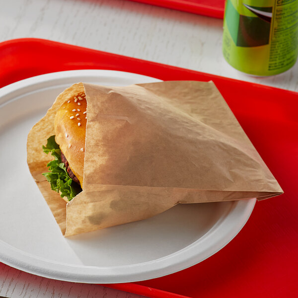 A Bagcraft EcoCraft paper bag holding a hamburger on a plate.
