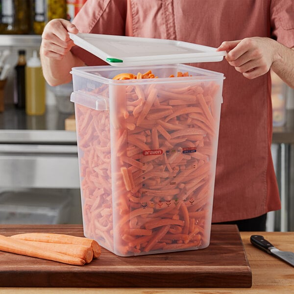 A man using an Araven translucent plastic container to store carrots.