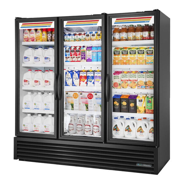 A True black refrigerated glass door merchandiser filled with milk and juice.