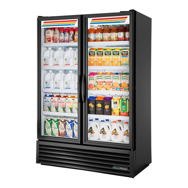 A True black refrigerated glass door merchandiser full of milk and juice.