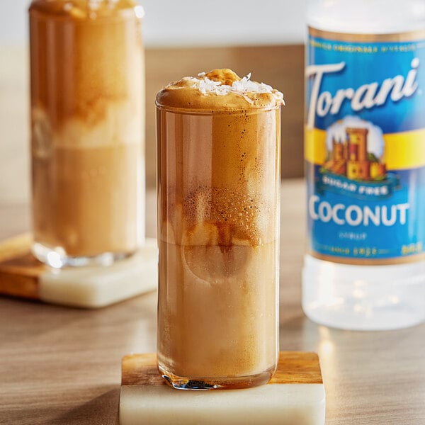 A glass of brown liquid with Torani Sugar-Free Coconut Flavoring syrup.