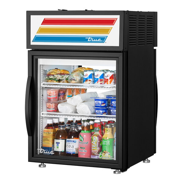 A black True countertop glass door refrigerator filled with food and drinks.