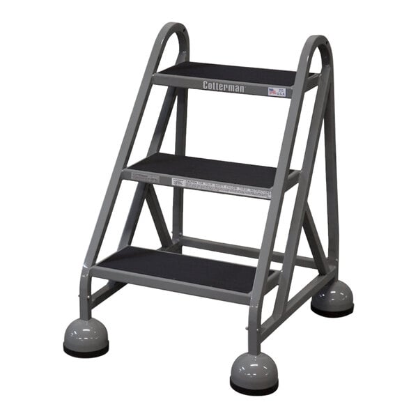 A gray Cotterman 3-step steel rolling ladder.