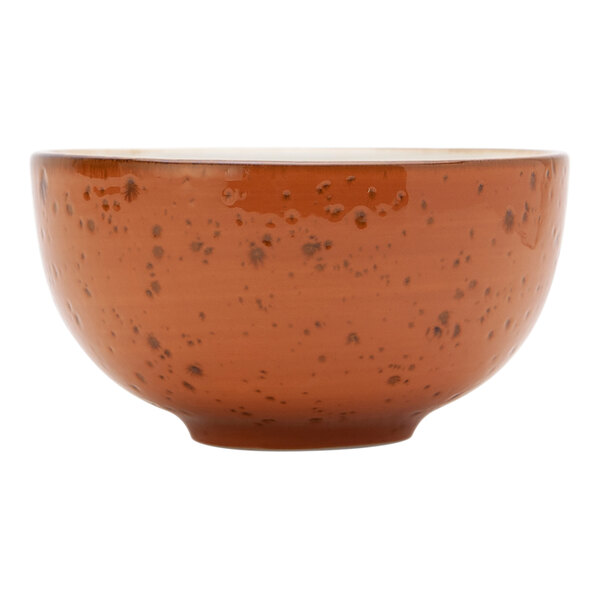A coral Tuxton soup bowl with brown specks.
