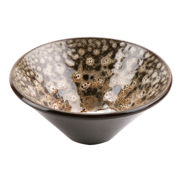 A brown and white cheforward terracotta bowl with a speckled surface.