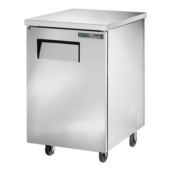 A silver True back bar refrigerator with a solid door on wheels.