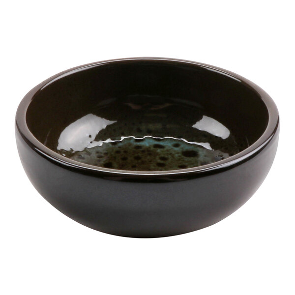 A black terracotta bowl with a green speckled surface and brown rim.