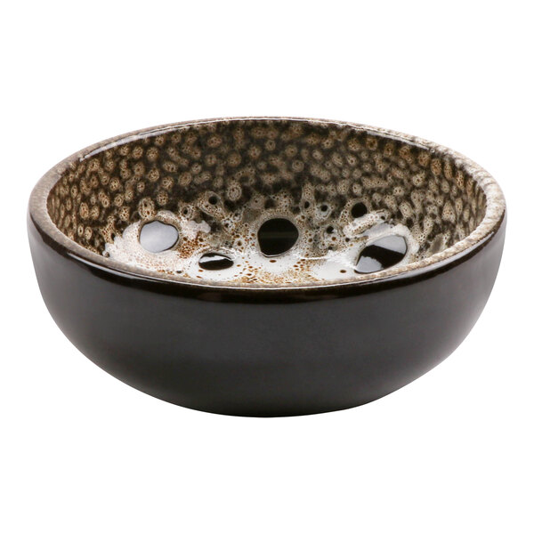 A terracotta bowl with a black, brown, and white speckled surface.
