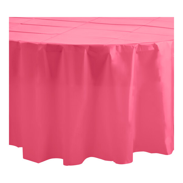 A hot pink round Table Mate plastic table cover on a white table.