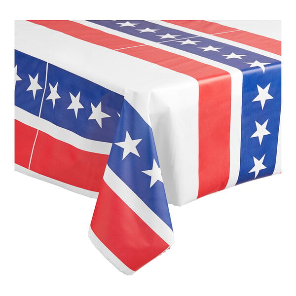 A Table Mate patriotic plastic tablecloth roll with red, white, and blue stars and stripes on a table.