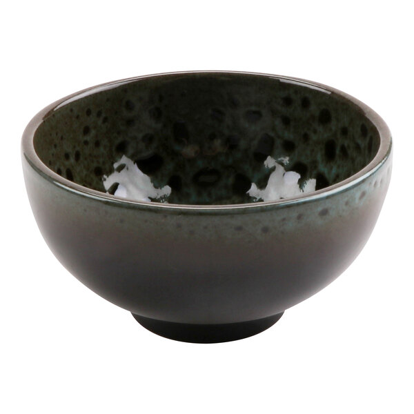 A terracotta bowl with black and green speckled design.