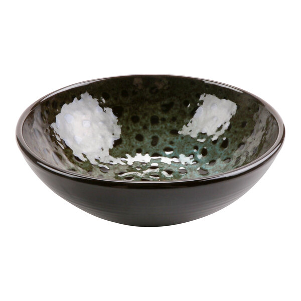 A terracotta bowl with a speckled green and white surface.