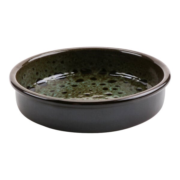 A green terracotta casserole dish with a speckled surface and a heart-shaped hole in the middle.