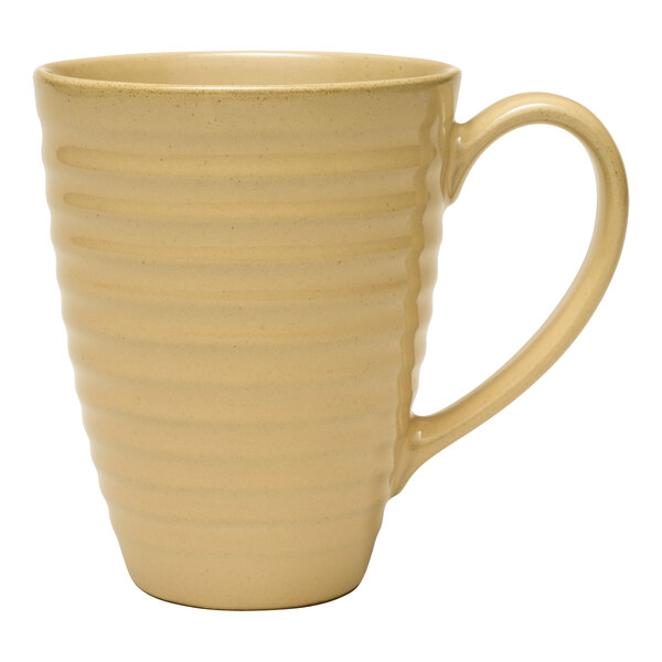 A close up of a Libbey tan terracotta mug with a handle on a white surface.