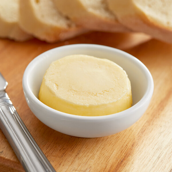 A bowl of Echire salted churned butter next to a knife and bread.