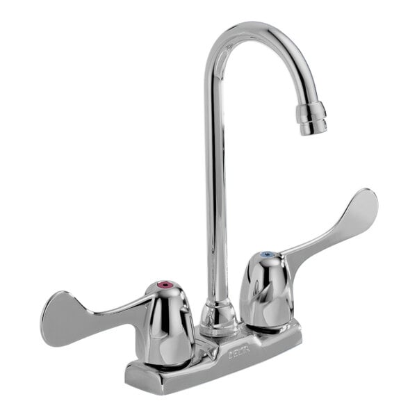 A Delta deck-mount kitchen faucet with blade handles and a gooseneck spout.
