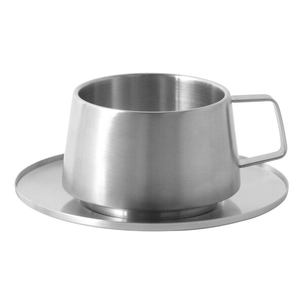 A silver cup on a stainless steel saucer.